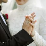 close up on couple holding hands together at wedding