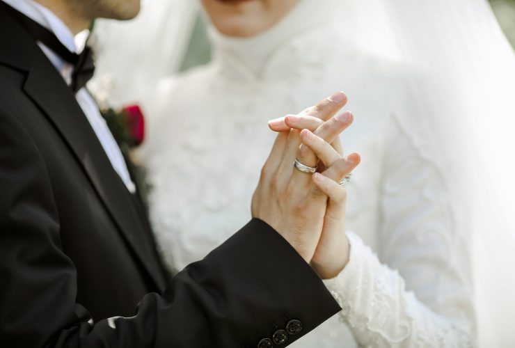 close up on couple holding hands together at wedding