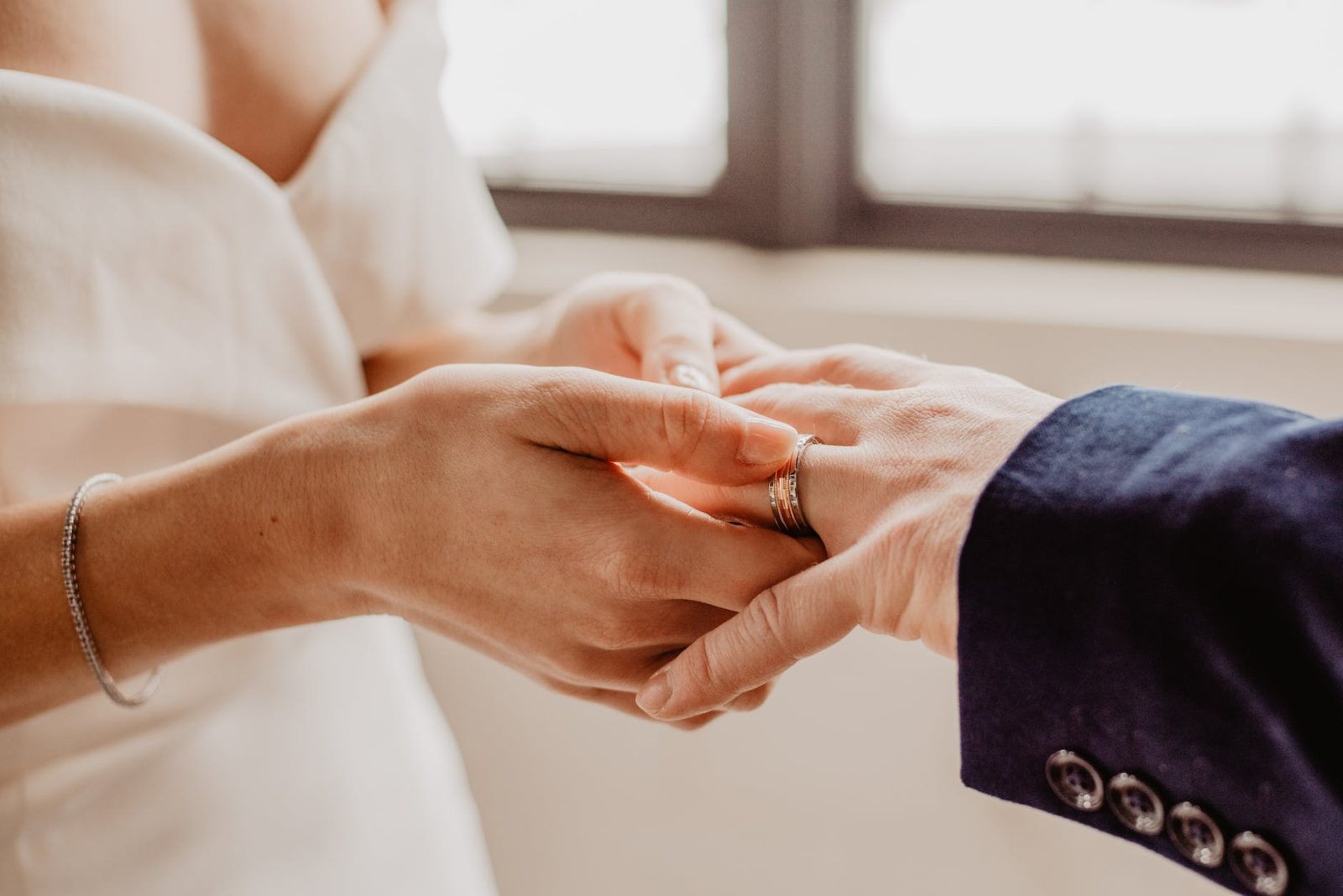 woman putting ring on person s hand