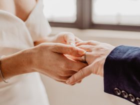 woman putting ring on person s hand