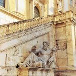 statue of zeus beside a staircase