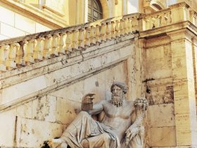 statue of zeus beside a staircase