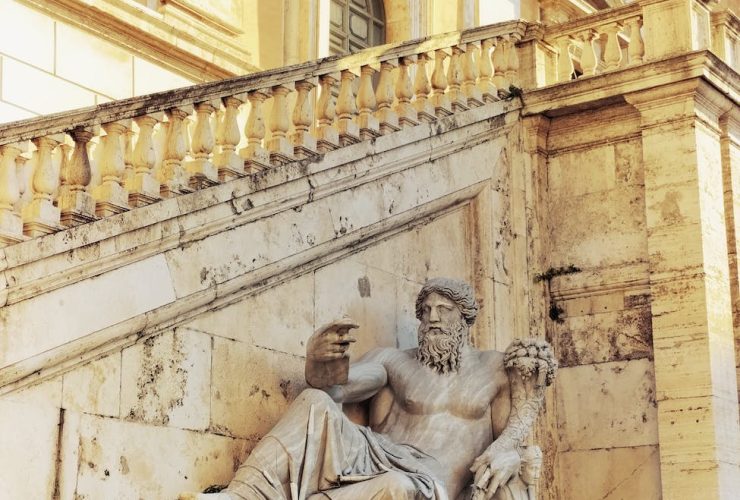 statue of zeus beside a staircase