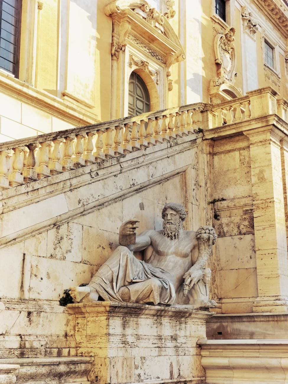 statue of zeus beside a staircase