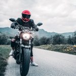 a man riding a motorcycle down a curvy road