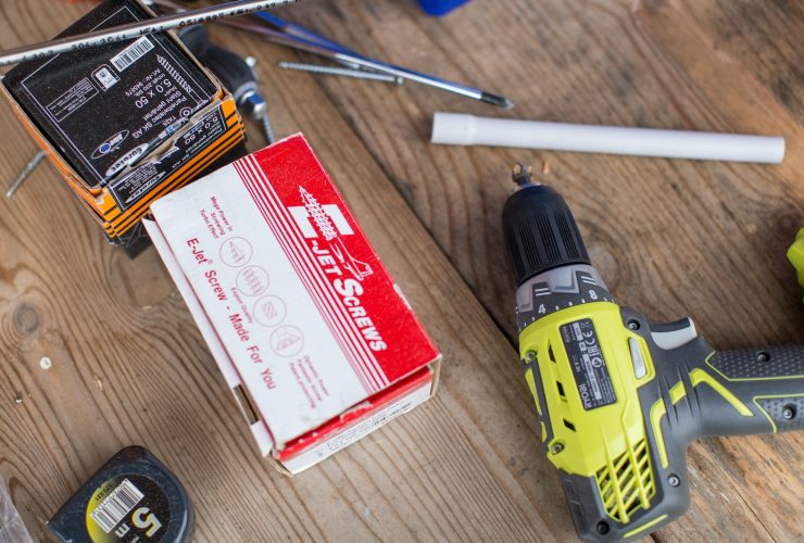 green Ryobi hand drill near white and red box