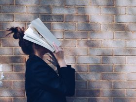 woman covering her face with white book