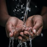 pouring water on person's hands