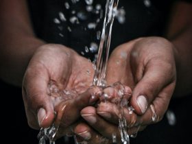 pouring water on person's hands