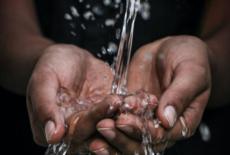 pouring water on person's hands