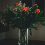red and yellow flowers in clear glass vase