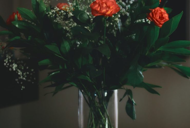 red and yellow flowers in clear glass vase