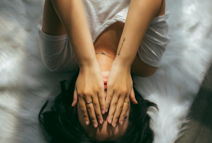 a woman holds her hands over her face