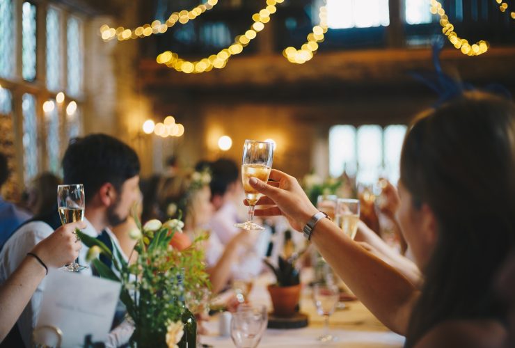 people raising wine glass in selective focus photography