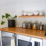 a kitchen counter with a microwave and a potted plant