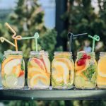 six clear glass mason jars filled with juice on black table