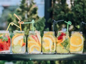 six clear glass mason jars filled with juice on black table