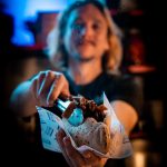 a woman holding a sandwich in front of a bar