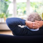 man lying on black couch