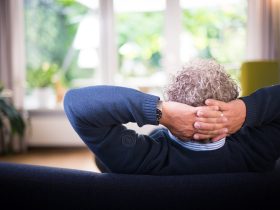 man lying on black couch