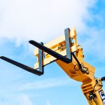 yellow and black crane under white clouds and blue sky during daytime