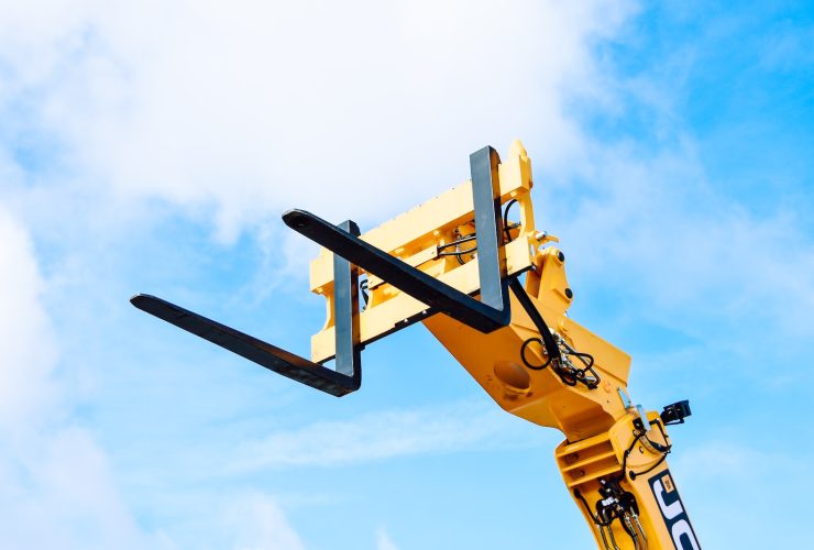 yellow and black crane under white clouds and blue sky during daytime