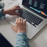 person wearing long-sleeve top working on laptop