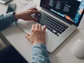 person wearing long-sleeve top working on laptop