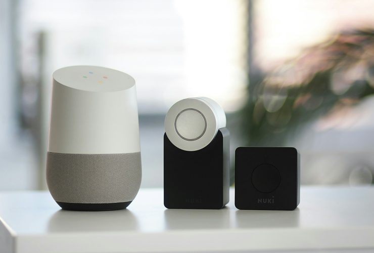 white and gray Google smart speaker and two black speakers