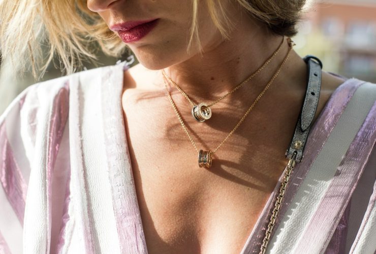 woman wearing gold-colored ring pendant necklaces