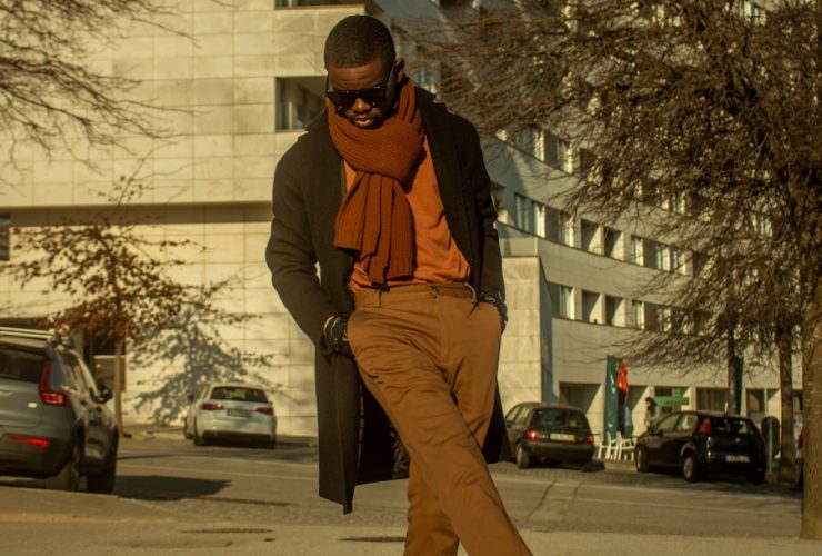 a man in brown pants and an orange scarf