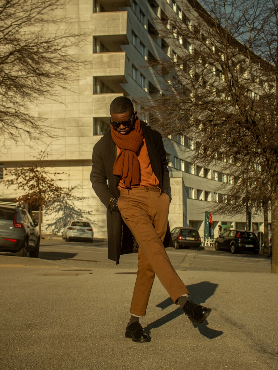 a man in brown pants and an orange scarf