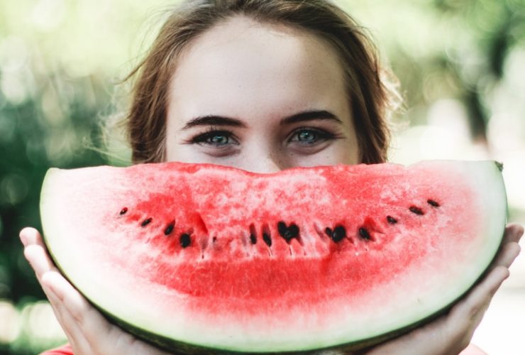 woman holding sliced watermelon