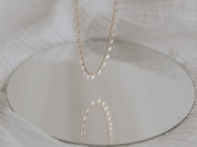 gold necklace on white textile