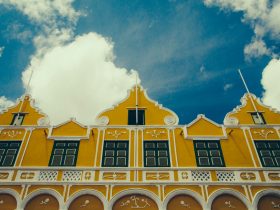 a yellow building with a clock on the front of it