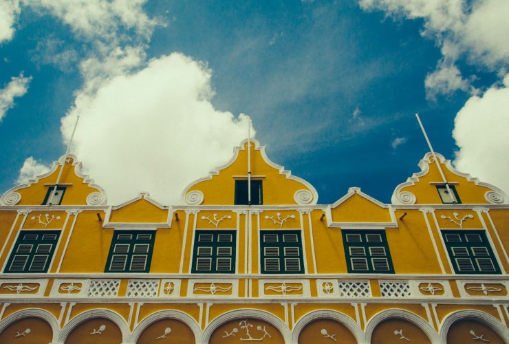 a yellow building with a clock on the front of it