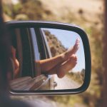 person's leg resting on vehicle window