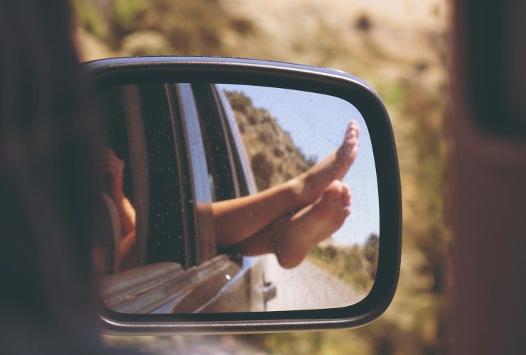 person's leg resting on vehicle window