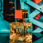 clear glass perfume bottle on blue surface