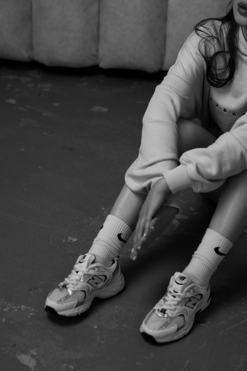 a black and white photo of a girl sitting on the floor
