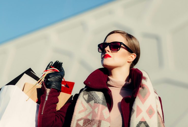 shallow focus photography of woman holding shopping bags during day