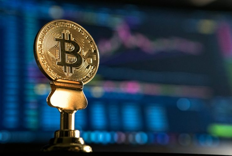selective focus photo of Bitcoin near monitor