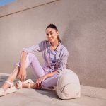 Vrouw op straat met oversized zonnebril en gestapelde armbanden als accessoires
