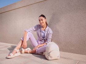 Vrouw op straat met oversized zonnebril en gestapelde armbanden als accessoires