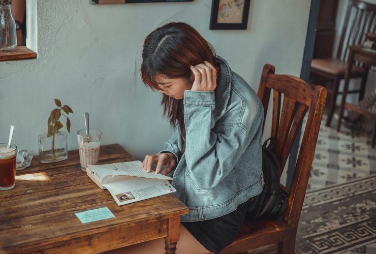 Vrouw die rustig schrijft in een notitieboekje in een gezellig café, als symbool voor bewuste zelfreflectie