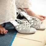 Elegante witte bruidsschoenen op een houten vloer