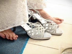 Elegante witte bruidsschoenen op een houten vloer