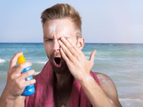 Minerale zonnebrand op het strand naast zonnebril en handdoek