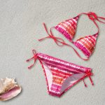 Vrouw op het strand in een duurzame zwembroek van gerecycled materiaal