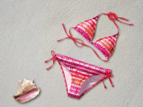 Vrouw op het strand in een duurzame zwembroek van gerecycled materiaal